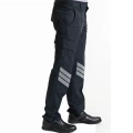 Side view of a person wearing black cargo pants with multiple pockets and reflective diagonal stripes near the calves, paired with black shoes.